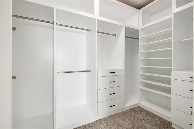 a view of walk in closet with empty racks