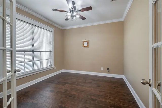 a view of an empty room with a window and wooden floor