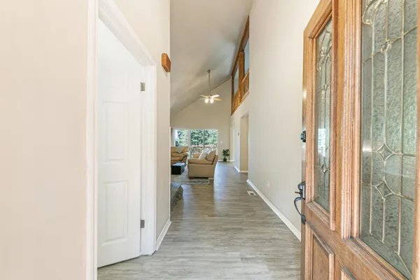 a view of a hallway with living room and wooden floor