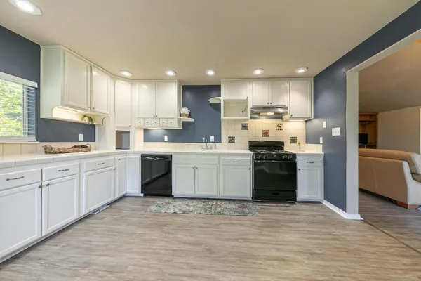 a kitchen with a sink stove cabinets and refrigerator
