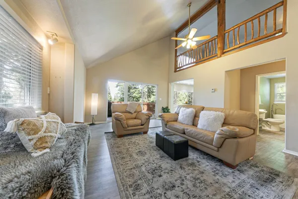 a living room with furniture wooden floor and a large window