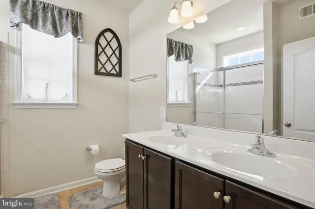 a bathroom with a sink a toilet and mirror