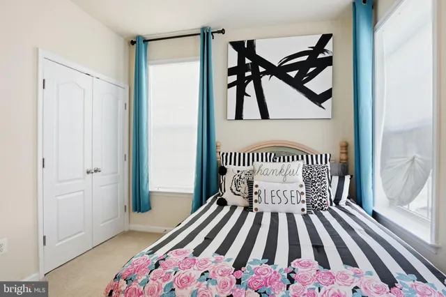 a view of a bedroom with a bed and wooden floor
