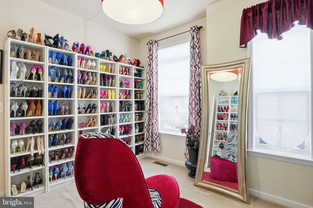 a view of walk in closet with clothes and shoes