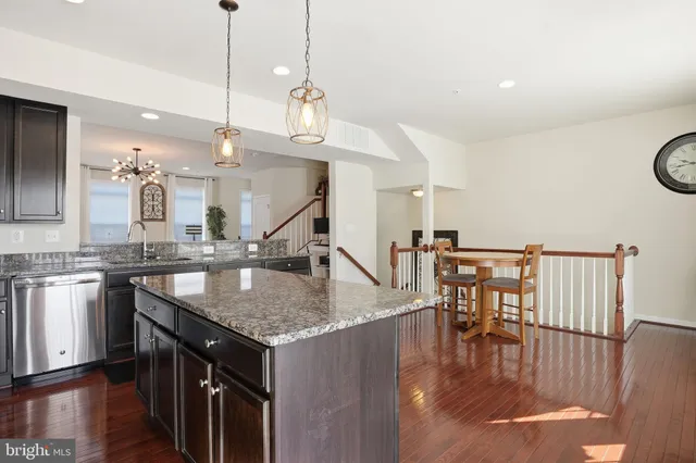 a kitchen with a table chairs stove and wooden floor