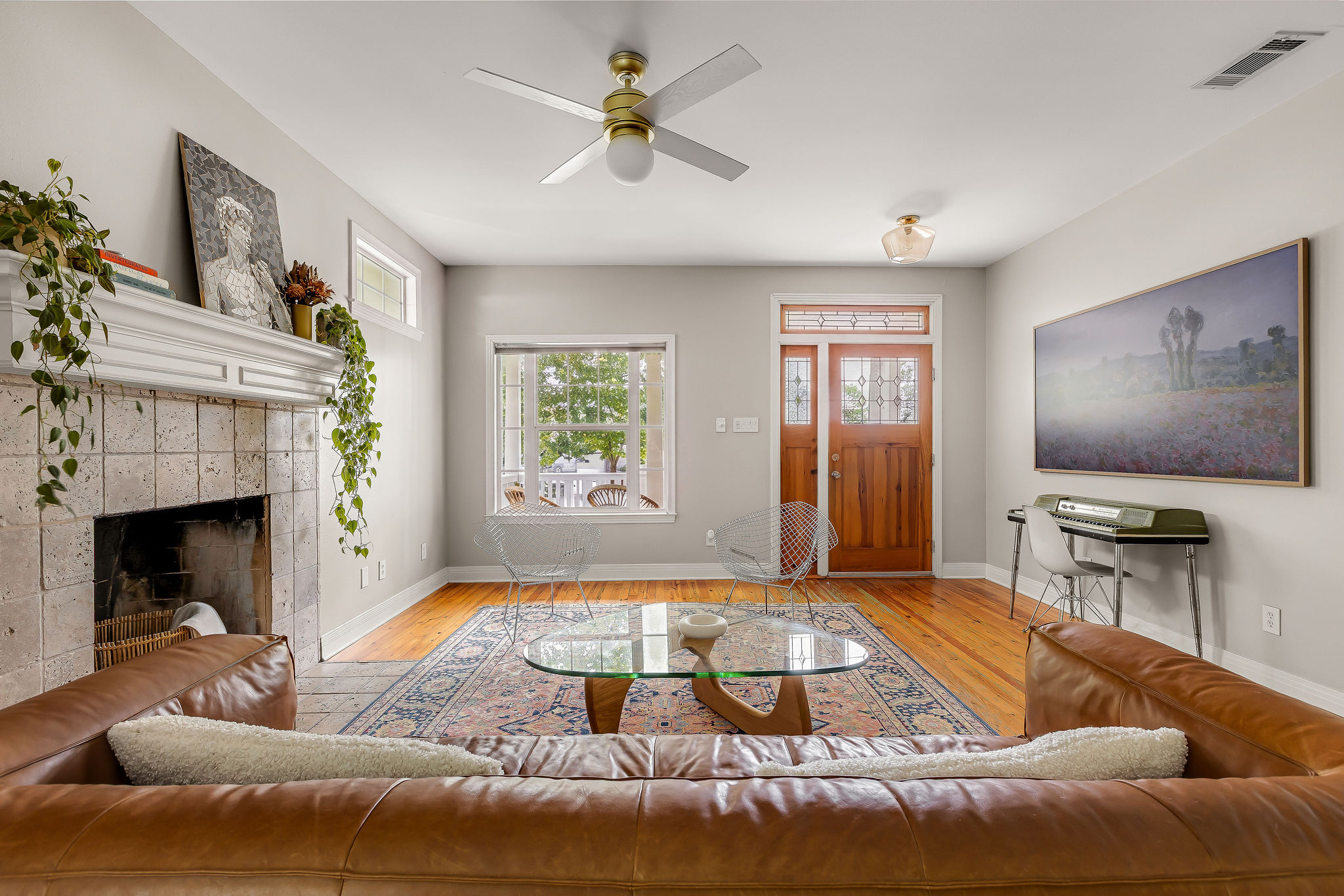 5108 Eilers Avenue Austin, TX 78751 - Photo 5 of 39 A sun-filled living area featuring a cozy fireplace and rich hardwood flooring.