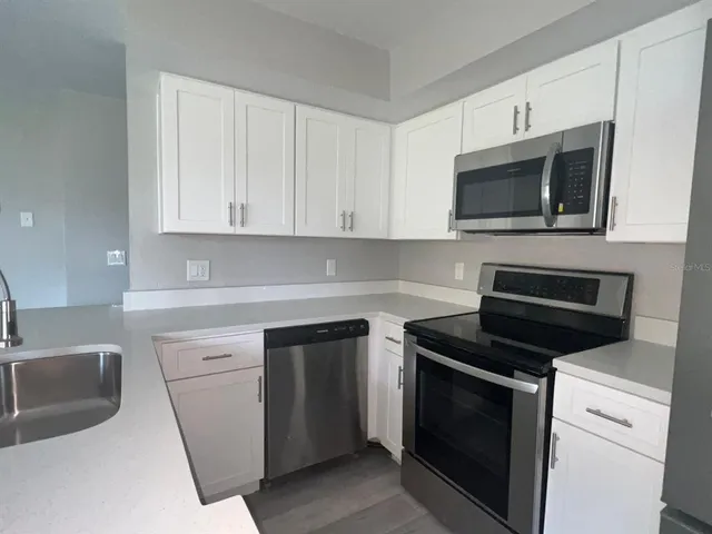 a kitchen with stainless steel appliances a refrigerator stove microwave and sink