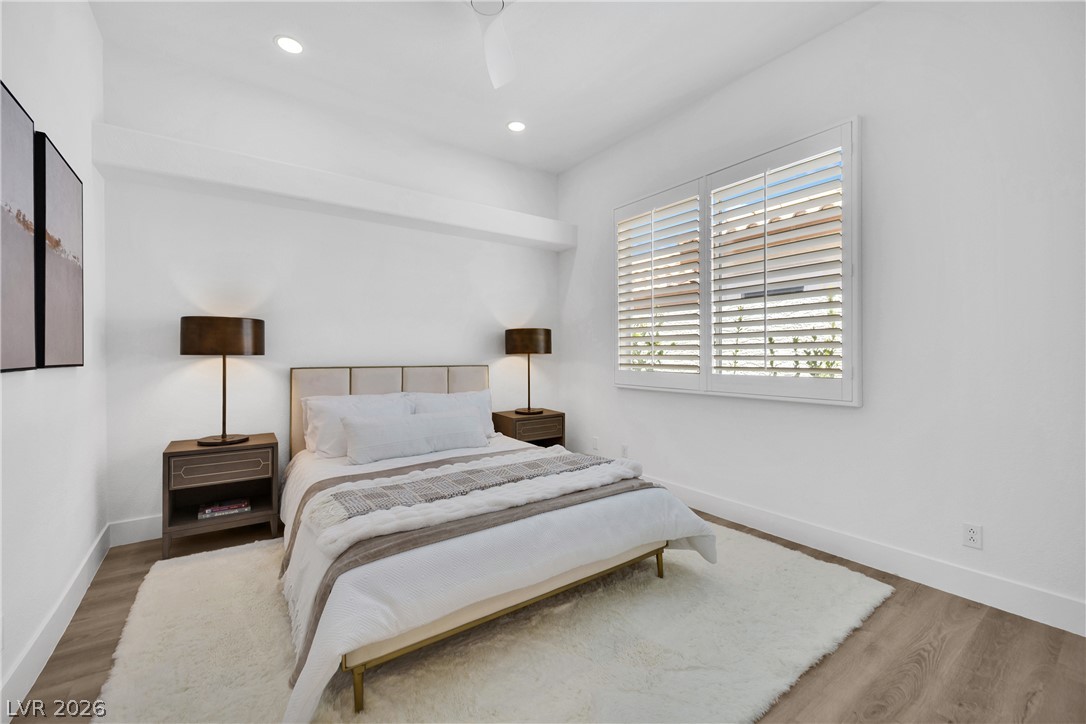 8981 Rivers Edge Drive Las Vegas, NV 89117 - Photo 42 of 69 Recessed lighting illuminates this bright bedroom with a sleek bed frame and plantation shutters.