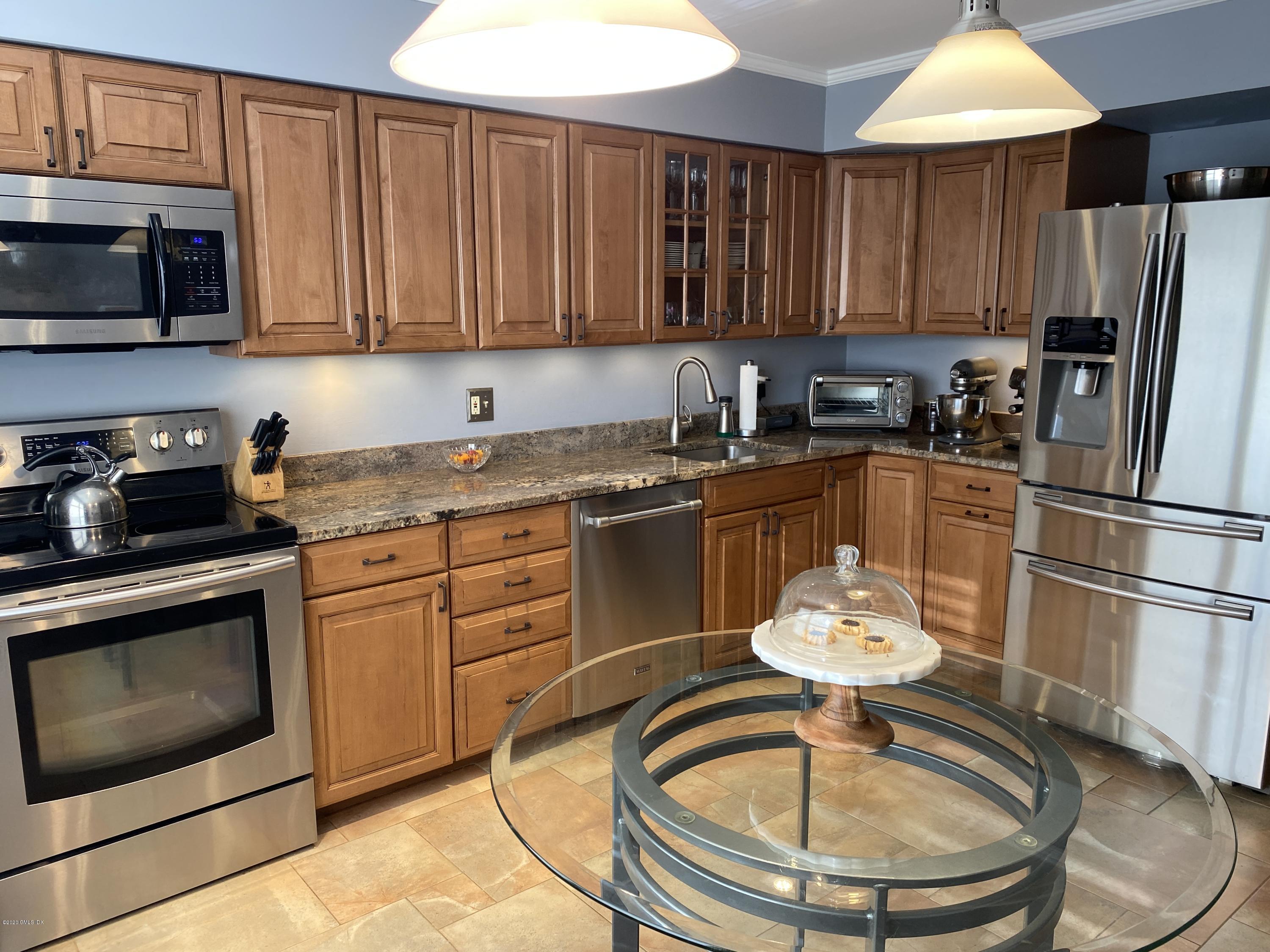 351 Pemberwick Road, Unit 607 Greenwich, CT 06831 - Photo 7 of 21 a kitchen with stainless steel appliances granite countertop a sink refrigerator and cabinets