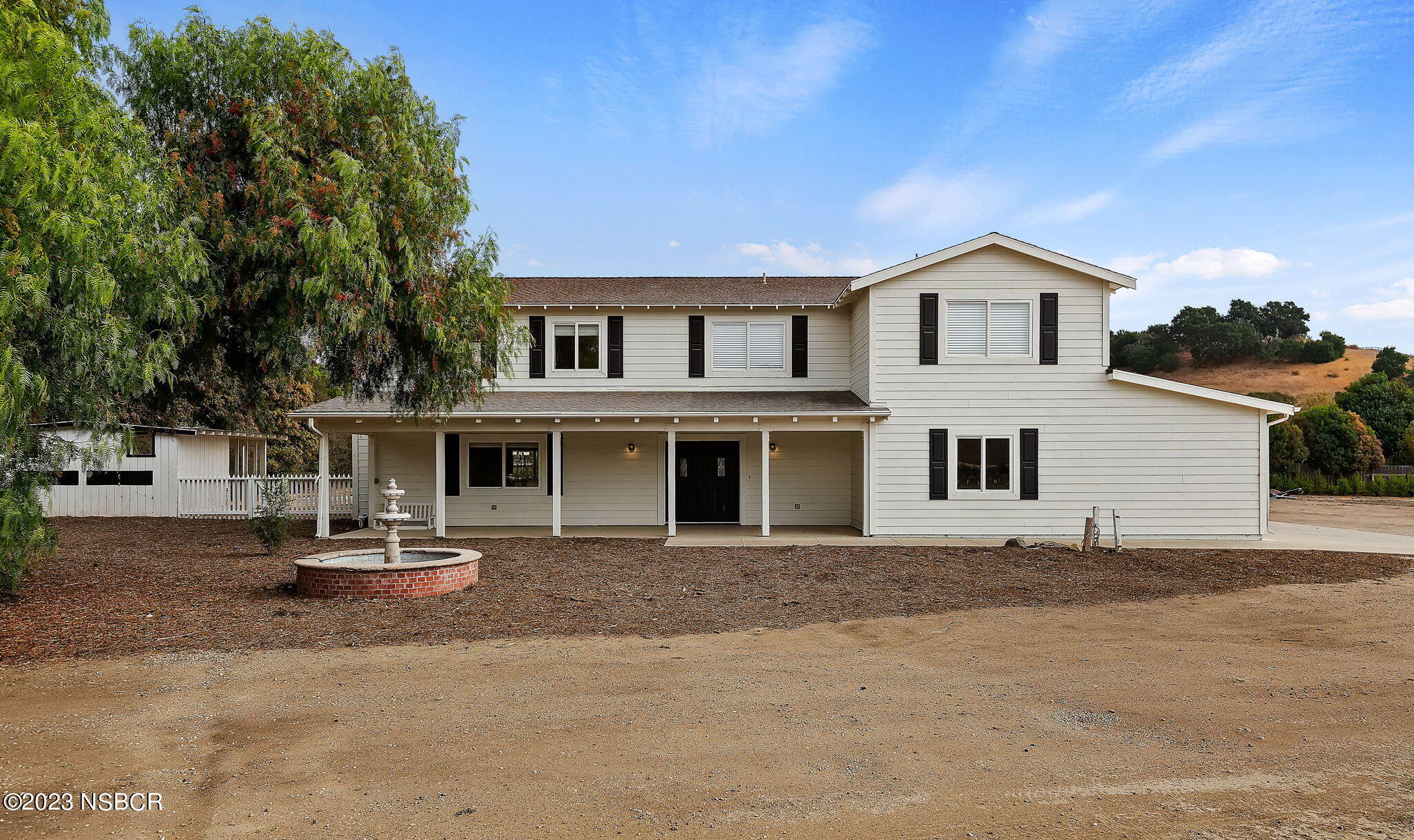 a front view of a house with a garden