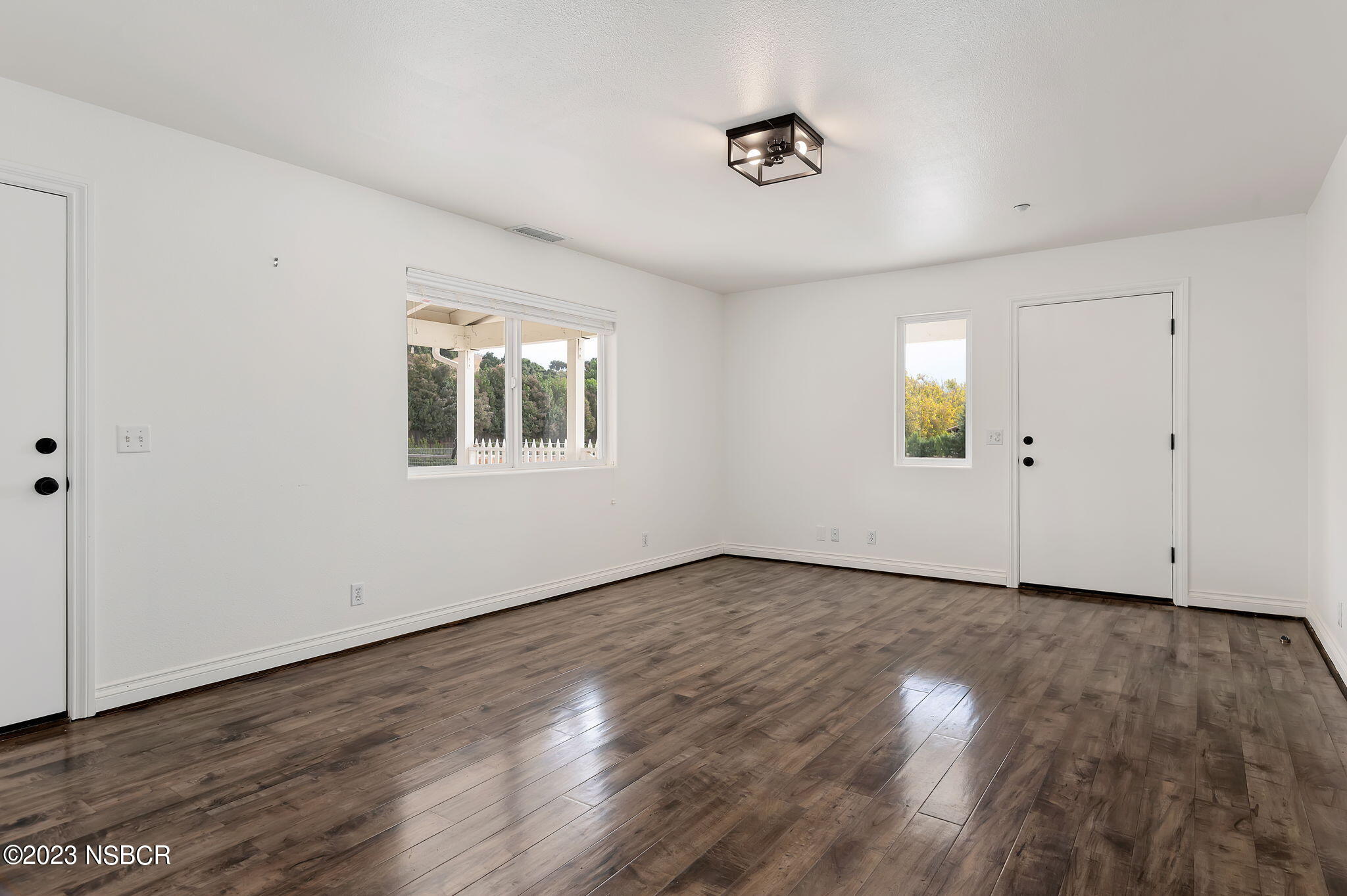 1180 Alamo Pintado Road Solvang, CA 93463 - Photo 8 of 20 an empty room with wooden floor and windows