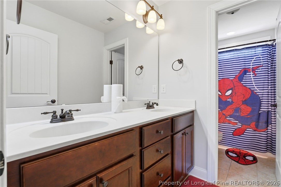 886 Micahs Way North Spring Lake, NC 28390 - Photo 30 of 50 a bathroom with a sink a mirror and a shower