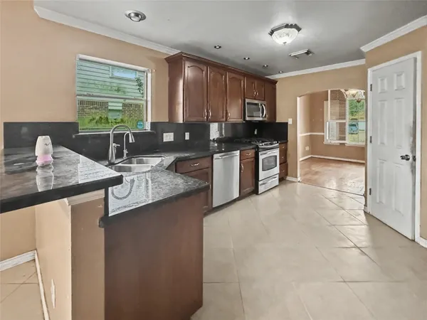 a kitchen with stainless steel appliances granite countertop a sink stove and refrigerator