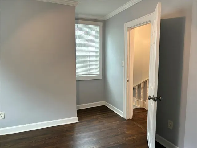an empty room with wooden floor and a window
