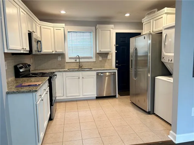 a kitchen with stainless steel appliances granite countertop a refrigerator a sink a stove a microwave and island