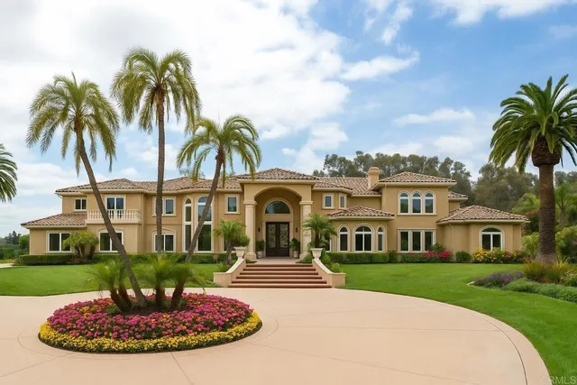 a front view of a house with a garden and trees