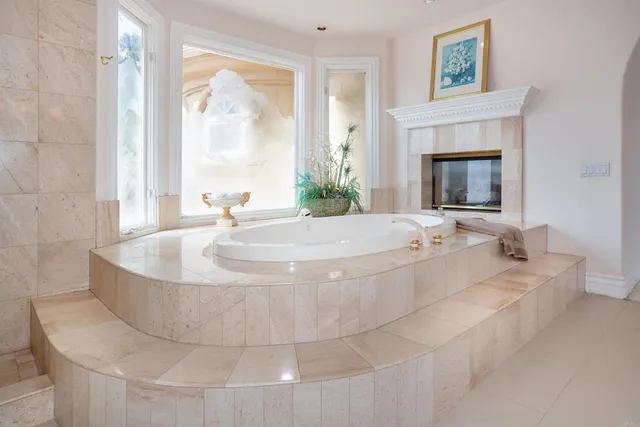 a living room with furniture a flat screen tv and a refrigerator