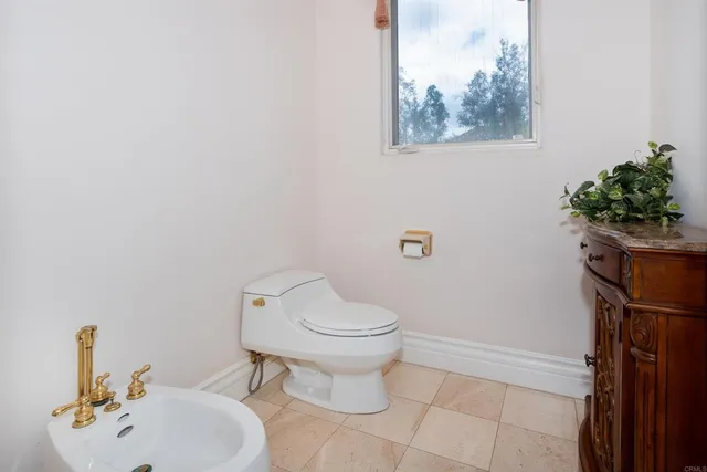 a kitchen with granite countertop a stove a sink dishwasher and white cabinets with wooden floor