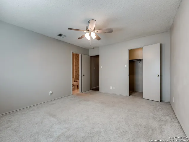 a view of an empty room with a ceiling fan