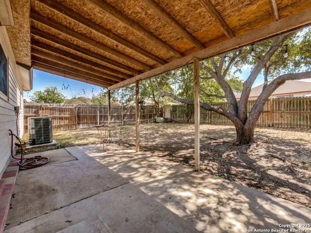 a view of a backyard with wooden fence