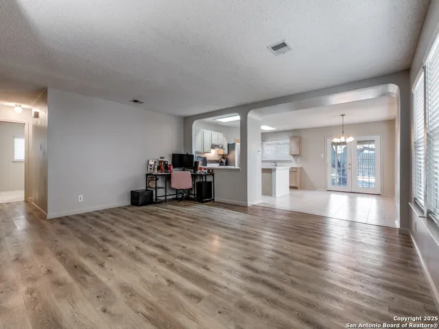 a view of a livingroom with a furniture wooden floor and a kitchen