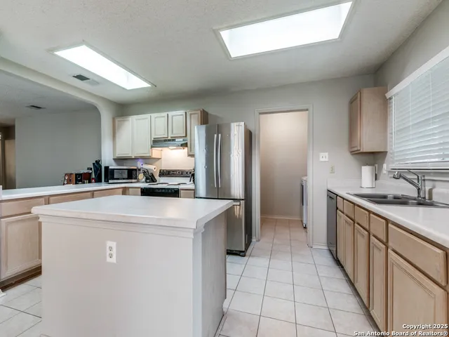 a kitchen with stainless steel appliances a refrigerator sink and cabinets