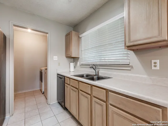 a kitchen with stainless steel appliances granite countertop a sink and dishwasher with wooden cabinets
