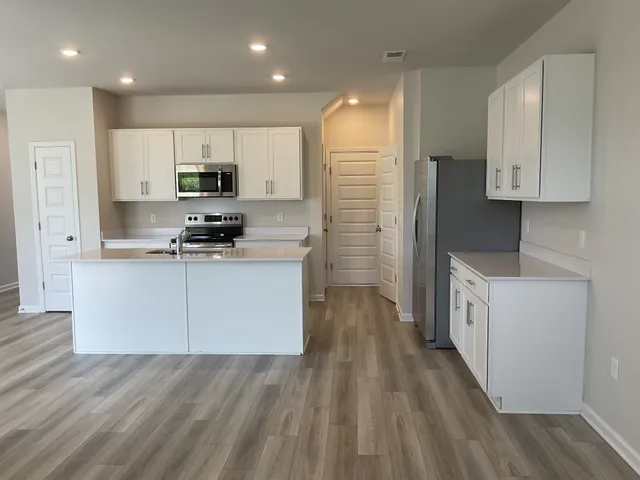 a kitchen with stainless steel appliances a refrigerator sink and cabinets