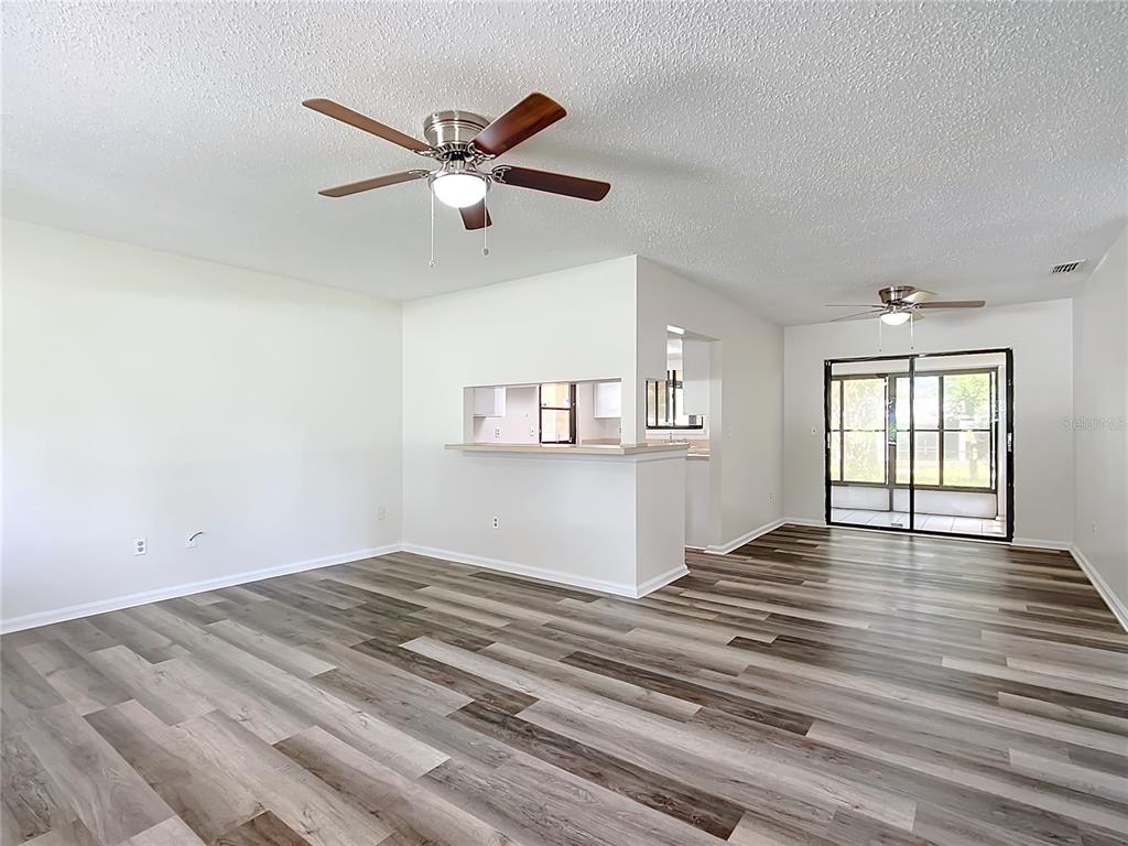 8917 Southwest 104th Place Ocala, FL 34481 - Photo 2 of 41 a view of empty room with wooden floor and ceiling fan