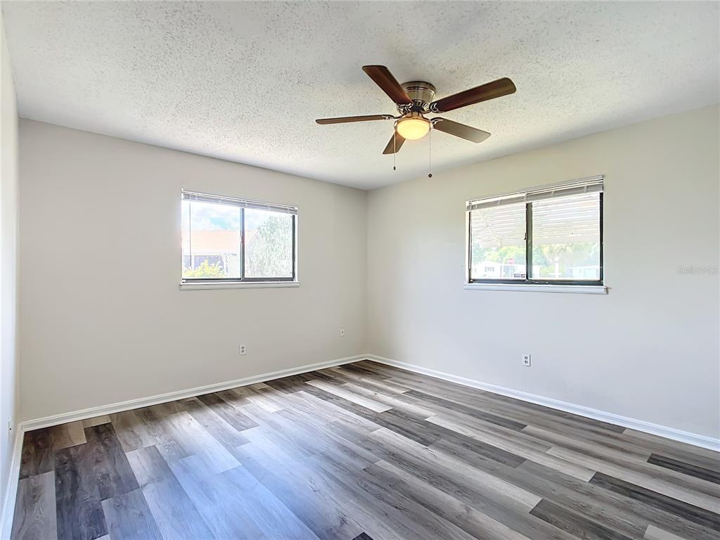 8917 Southwest 104th Place Ocala, FL 34481 - Photo 22 of 41 a view of empty room with wooden floor and fan