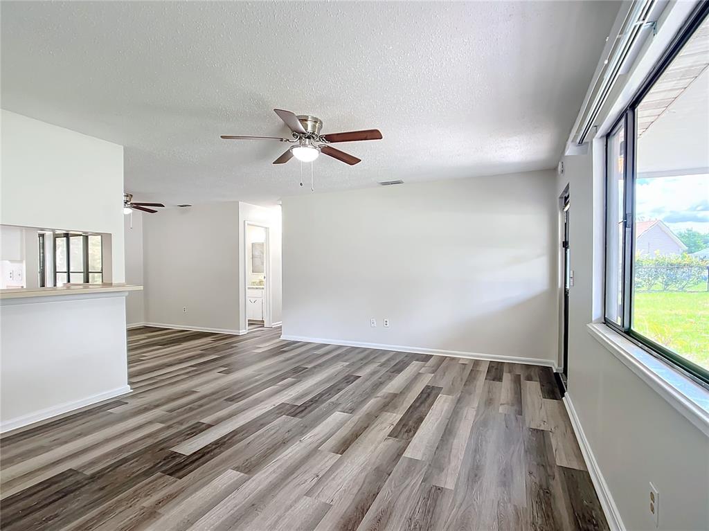 8917 Southwest 104th Place Ocala, FL 34481 - Photo 5 of 41 a view of empty room with wooden floor and fan