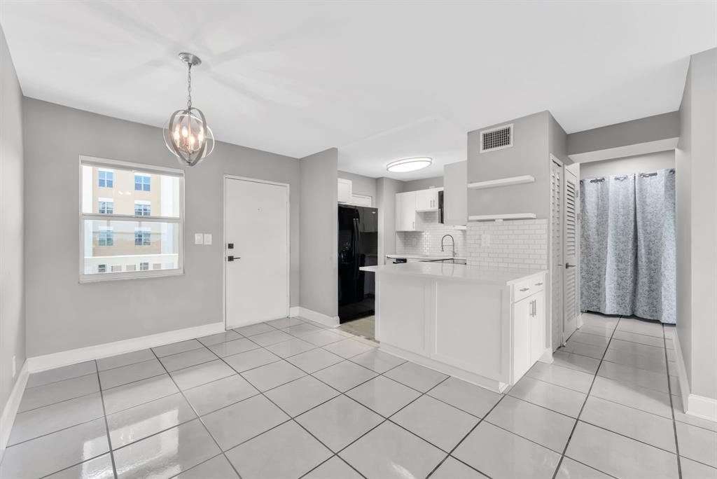 2555 Northeast 11th Street, Unit 708 Fort Lauderdale, FL 33304 - Photo 7 of 17 a kitchen with white cabinets and window