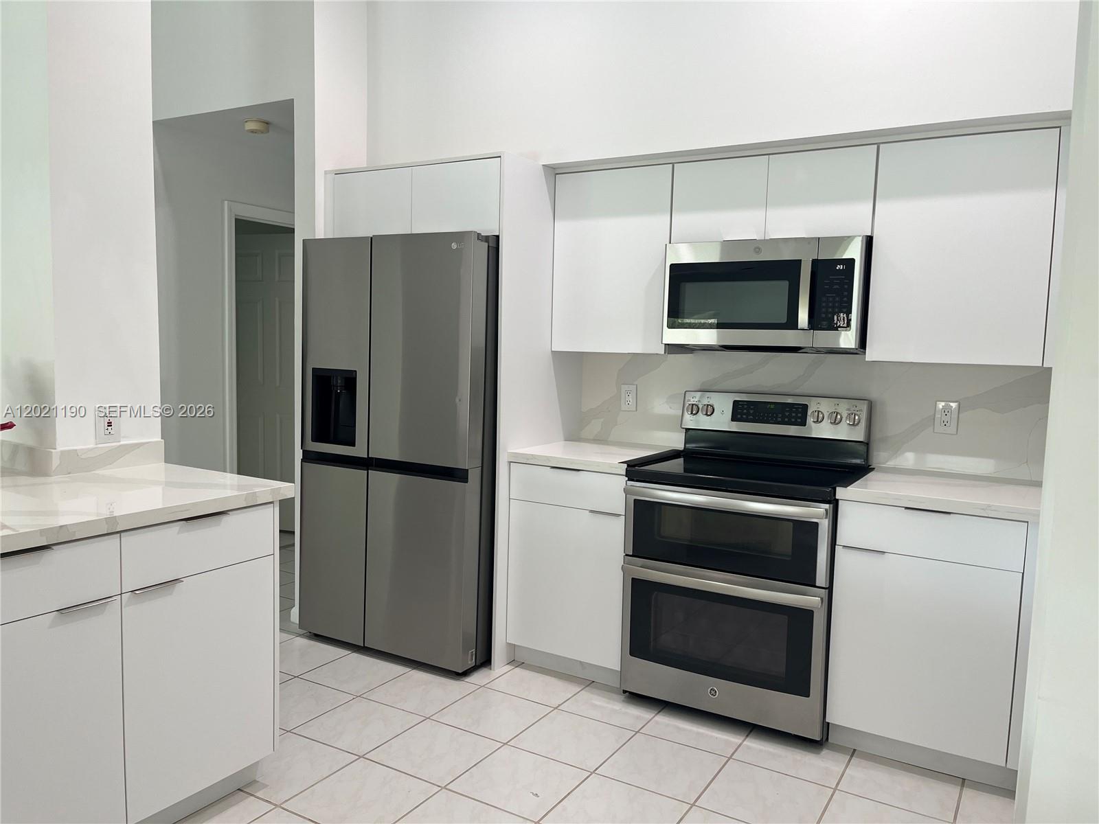 814 Heron Road Weston, FL 33326 - Photo 16 of 27 a kitchen with stainless steel appliances a refrigerator stove and microwave