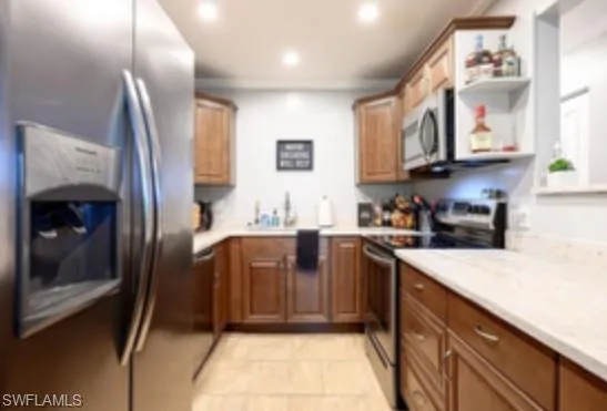 a kitchen with stainless steel appliances granite countertop a refrigerator and a sink