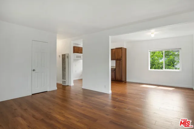 an empty room with wooden floor and a window