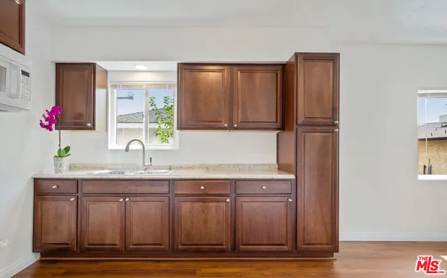 a kitchen with granite countertop a refrigerator and a sink