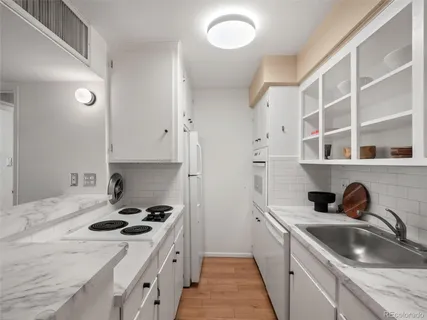 a kitchen with a sink stove top oven and cabinets