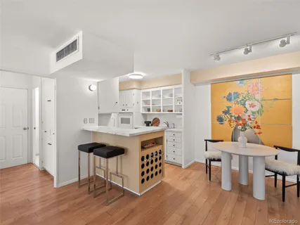a kitchen with stainless steel appliances a dining table chairs and wooden floor
