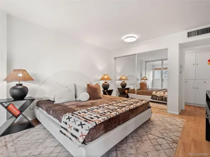 a bedroom with a bed and wooden floor