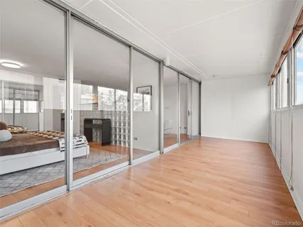 a view of empty room with wooden floor and floor to ceiling window