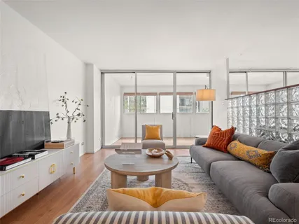 a living room with furniture a flat screen tv and a large window