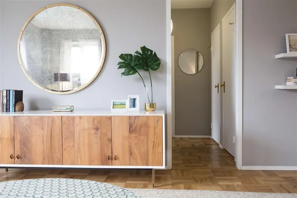 an entryway with wooden floor and a mirror