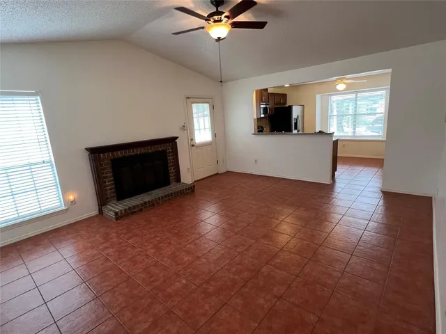 an empty room with windows fireplace and windows
