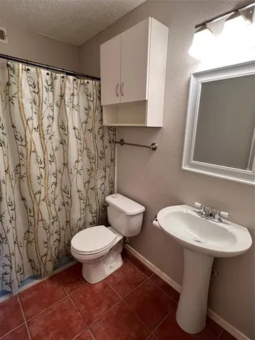 a bathroom with a sink toilet and a mirror