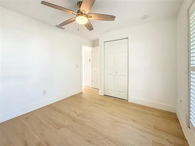 an empty room with fan and a ceiling fan