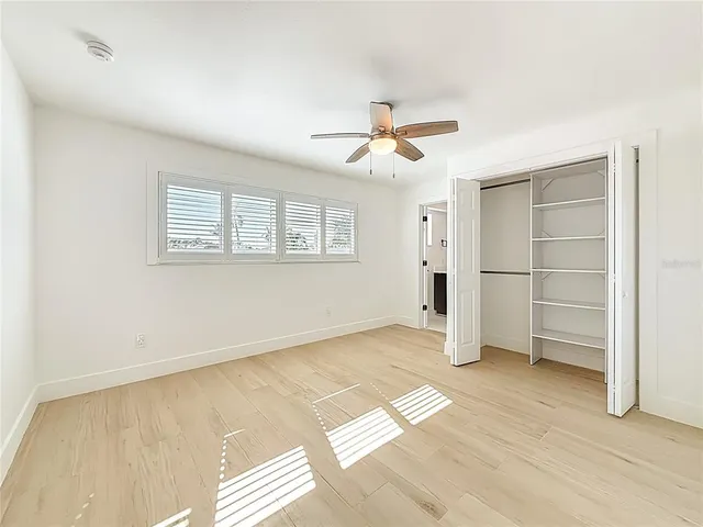 a view of empty room with wooden floor and window