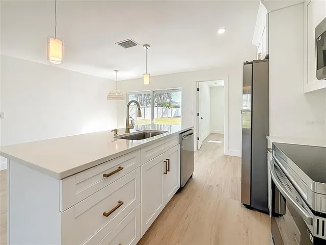 a large kitchen with a lot of counter space and wooden floor