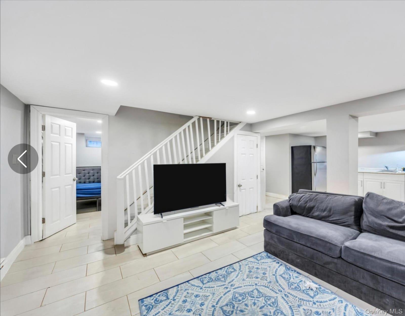55 Amityville Road Melville, NY 11747 - Photo 19 of 21 a living room with furniture and a flat screen tv