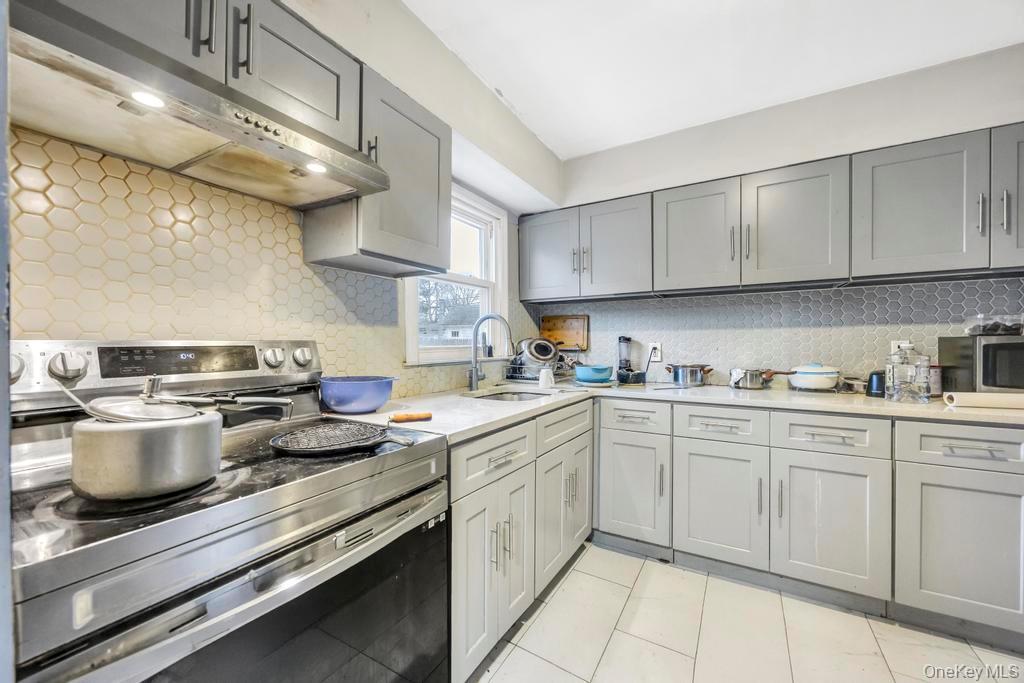 55 Amityville Road Melville, NY 11747 - Photo 8 of 21 a kitchen with a stove cabinets and a sink