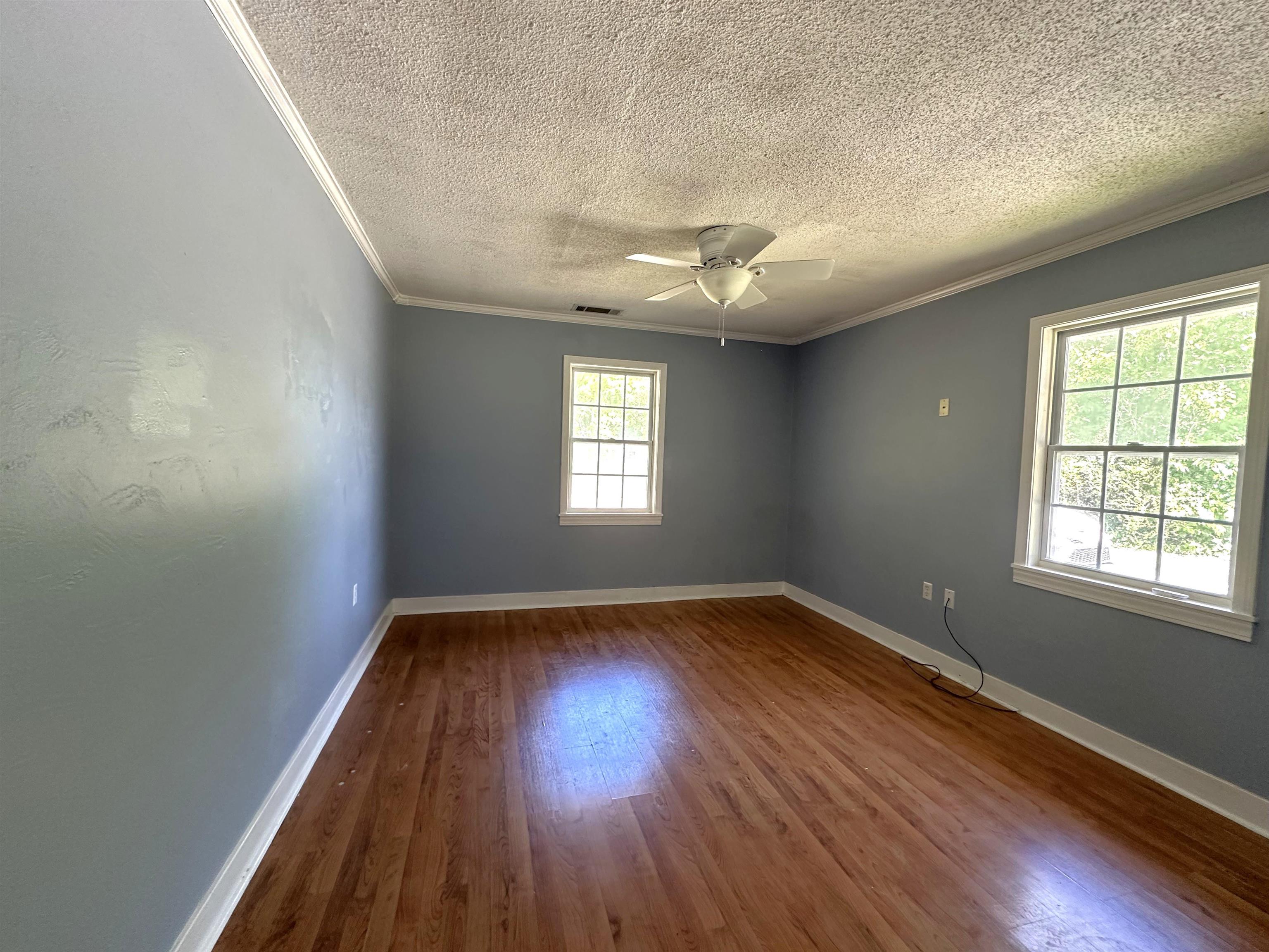 7874 Shamrock Road Millington, TN 38053 - Photo 8 of 17 Spacious room featuring wood-finish flooring, two window openings, a ceiling fan, and white trim details